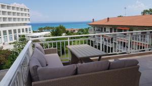 a balcony with a couch and a table and the ocean at Luxury penthouse with sea view in Hanioti