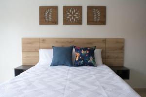 a bedroom with a white bed with pillows on it at Azalea Hotel in Zipaquirá