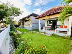 a backyard of a house with a green yard at Solaluna Beach Homestay in Amed