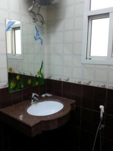 uma casa de banho com um lavatório e um espelho em Rimal Suites Apartments em Salalah