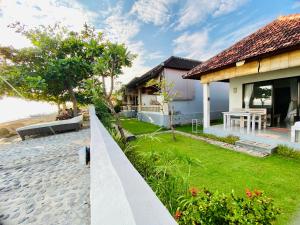 une villa avec un jardin et une maison dans l'établissement Solaluna Beach Homestay, à Amed