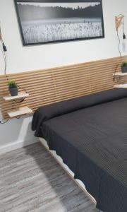 a bedroom with a bed with a wooden headboard at Apartamento Dos mares I in La Manga del Mar Menor