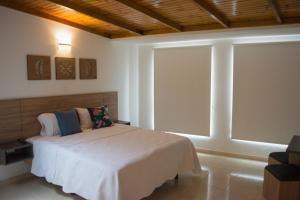 a bedroom with a bed and a large window at Azalea Hotel in Zipaquirá