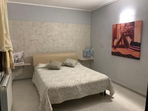 1 dormitorio con 1 cama y una pintura en la pared en S'Istentale en Porto Torres