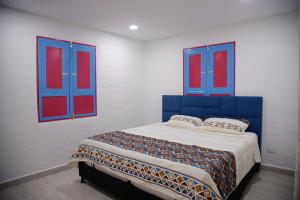 a bedroom with blue and red windows and a bed at Casa Adelina in Salento