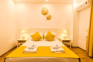 a bedroom with a bed with yellow sheets and yellow pillows at Kybele Suites in Kaş