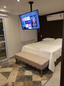 a bedroom with two beds and a tv on the wall at Flat 2211 - Guarulhos Aeroporto - Wi-fi - Estacionamento - Home Office - Shoppings in Guarulhos