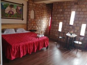 a bedroom with a red bed and a table with chairs at Castillo de Tarapoto in Tarapoto