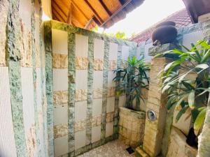 a privacy fence with a plant in the corner at Solaluna Beach Homestay in Amed
