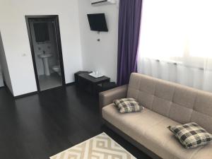 a living room with a couch and a mirror at Matei Mamaia-Nord in Mamaia Sat/Năvodari