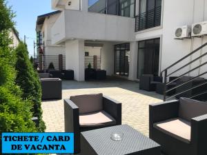 a patio with two chairs and a table in front of a building at Matei Mamaia-Nord in Mamaia Sat/Năvodari