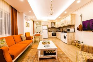 a living room with an orange couch and a table at Kybele Suites in Kaş