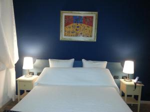 a bedroom with a large white bed with two lamps at Hotel Argentina in Santa Margherita Ligure
