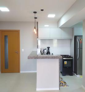 a kitchen with white cabinets and a counter top at Flat Paraiso dos Coqueiros in Guarajuba