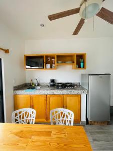 Il comprend une cuisine équipée d'un réfrigérateur en acier inoxydable et de chaises blanches. dans l'établissement SuitesMB, à Playa del Carmen