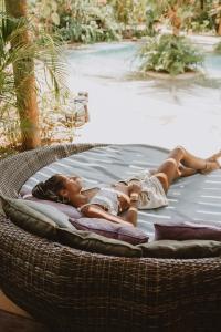a woman is laying on a wicker bed at Paua Hotel Boutique in Pipa