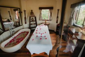 a bathroom with a bathtub and a claw foot bath tub at Paua Hotel Boutique in Pipa