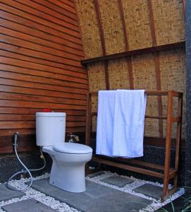 a bathroom with a toilet and a towel at D'Wahana Resort in Gili Trawangan +14 photos