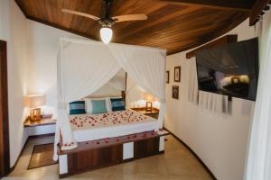 a bedroom with a bed with a ceiling fan at Paua Hotel Boutique in Pipa