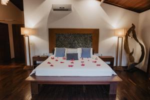a bedroom with a bed with red flowers on it at Paua Hotel Boutique in Pipa