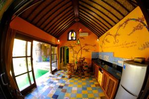 a kitchen with yellow walls and a checkered floor at Bali Bohemia Huts in Ubud