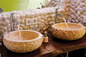 two bathroom sinks with faucets on a wooden table at Bali Bohemia Huts in Ubud