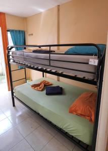 two bunk beds in a room with towels on them at Kalunai Hostel in Puerto Viejo