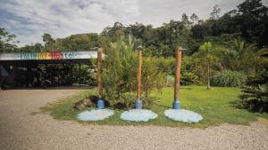 un grupo de tres postes de bambú sentados en la hierba en Kalunai Hostel en Puerto Viejo
