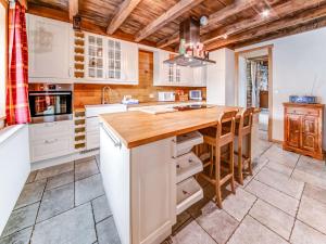 cocina con armarios blancos y encimera de madera en Beautiful home in L glise with a garden and pond en Léglise
