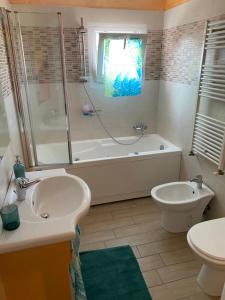 ein Badezimmer mit einer Badewanne, einem Waschbecken und einem WC in der Unterkunft E&C Suites Roma in Lido di Ostia