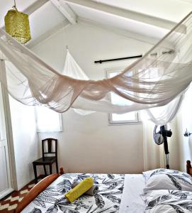 um quarto com uma cama e uma rede mosquiteira em Malendure Bay Appartements em Bouillante