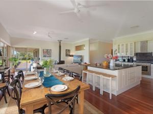 een eetkamer en een keuken met een tafel en stoelen bij Terara Riverview Estate in Terara