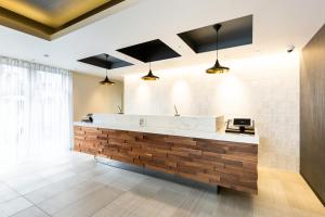 a lobby with a reception counter with wood at HOTEL M's EST KYOTO STATION SOUTH in Kyoto