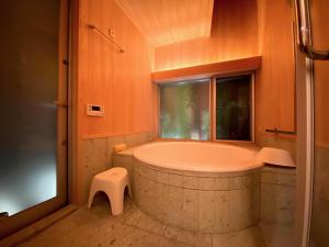 a bathroom with a large tub and a window at Sankoku Bashira in Kyoto