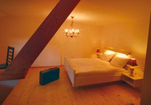 sypialnia z białym łóżkiem i żyrandolem w obiekcie Hotel Sternen - Anno 1769 w mieście Todtnauberg