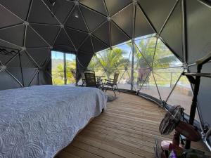 una camera da letto in una tenda a cupola con letto e sedie di Glamping Montecarlo Domo Geodesico y Sauna Finlandés Guatapé a Guatapé