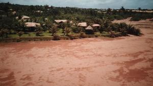 a large body of water with houses and palm trees at Paua Hotel Boutique in Pipa