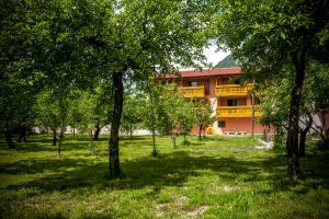 um edifício no meio de um parque com árvores em Apartments Masera em Kobarid