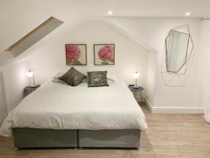 a bedroom with a bed with two lamps and a mirror at Large 3 Bedroom modern apartment close to central London in Finchley