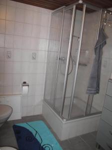 y baño con ducha y alfombra azul. en Nettetal - free2beme, en Nettetal