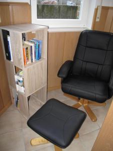 una silla de oficina negra sentada junto a un estante de libros en Nettetal - free2beme, en Nettetal