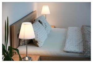 ein Bett mit zwei Lampen und zwei Kissen darauf in der Unterkunft Apartmán Wellness Sedmihorky in Turnov