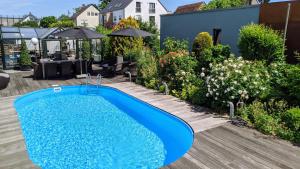 a swimming pool in a backyard with a garden at Hotel Rotes Ross in Erlangen
