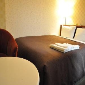 ein Hotelzimmer mit einem Bett mit Handtüchern darauf in der Unterkunft Hotel Select Inn Nagano in Nagano