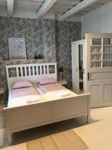 Cseri Porta Kisház في Szatta: غرفة نوم مع سرير أبيض مع وسائد وردية عليه