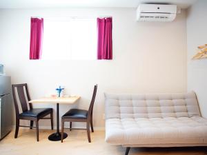 a living room with a couch and a table at Mcity in Furujima in Naha