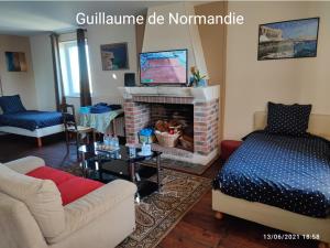 Fief des 3 Guillaume Chambres d'hôtes في Écouis: غرفة معيشة مع أريكة ومدفأة