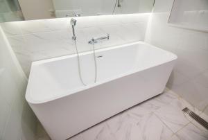 BLO BY BLO HOTEL في دايغو: حمام أبيض مع حوض ودش