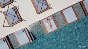 Colonides Beach Hotel في فوناريا: منظر علوي لامرأة في حمام سباحة