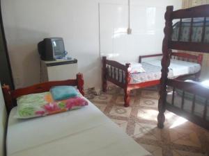 a bedroom with two bunk beds and a tv at Hostel Palmas Centro Da Cidade in Palmas